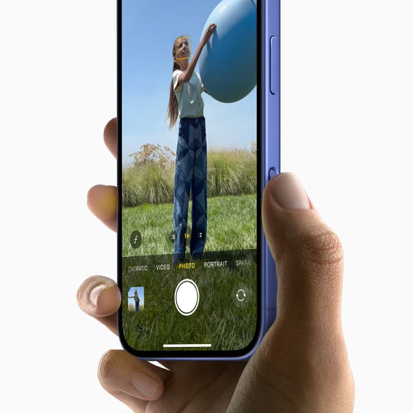 A picture of a person holding an iPhone 16, showcasing the Camera Control